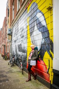 Nachdenklich vor einem gelben Graffiti in Rotterdam